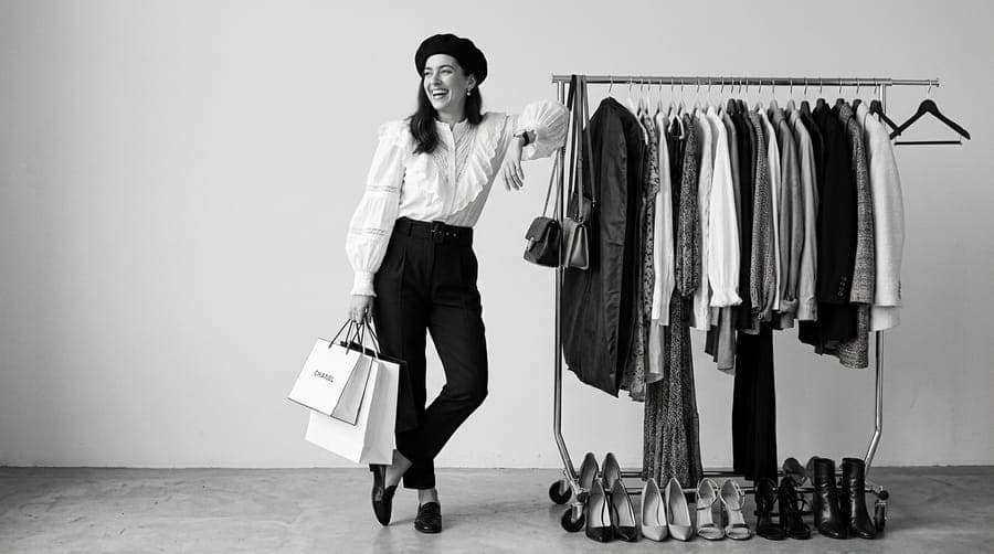 Shopper with bags beside a clothing rack